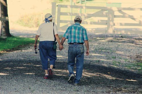 Старая пара, идущая, держась за руки