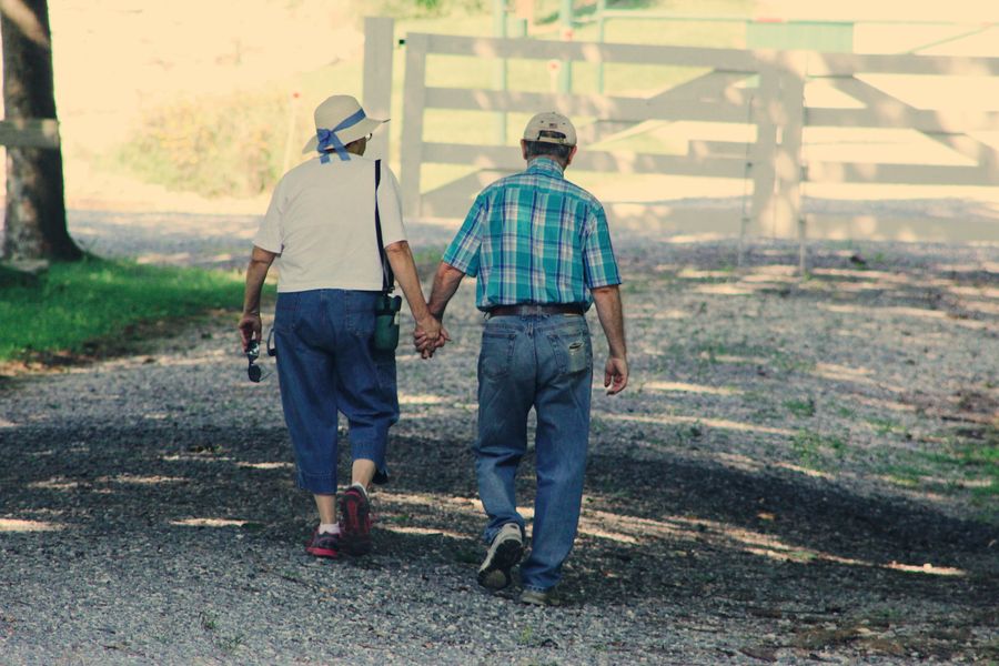 Older couple holding hands while walking outdoors