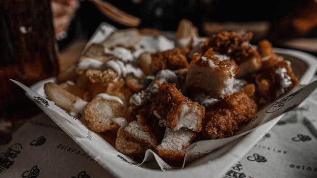 Delicious crispy chicken and fries with sauce in a Manchester restaurant, perfect for a tasty meal.
