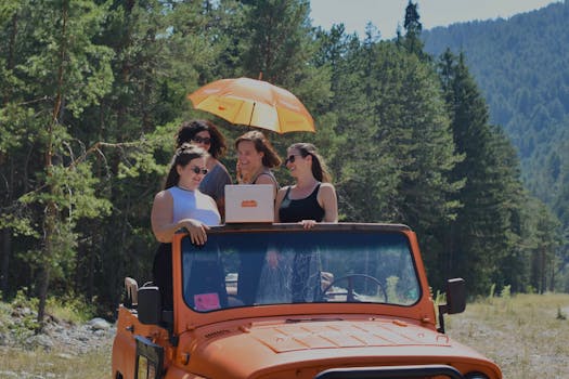 Four women having fun on a jeep ride under an umbrella in a picturesque forest setting.