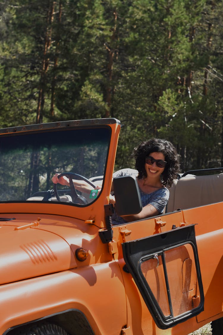 Woman With Sunglasses Driving An Orange Jeep