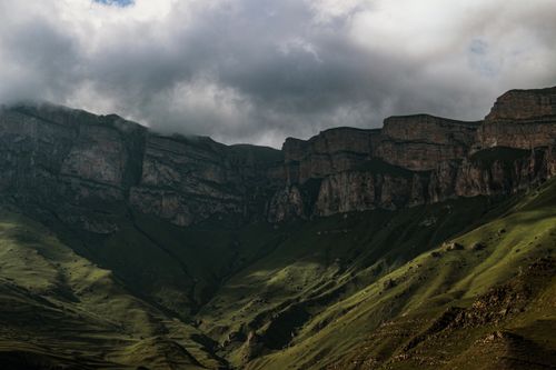 Free Charming view of rocky mountains beneath a dramatic, cloudy sky. Stock Photo