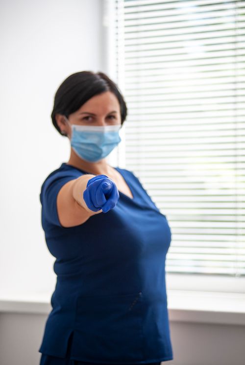 Free Close-up of a healthcare worker wearing a face mask and gloves, indoors. Stock Photo