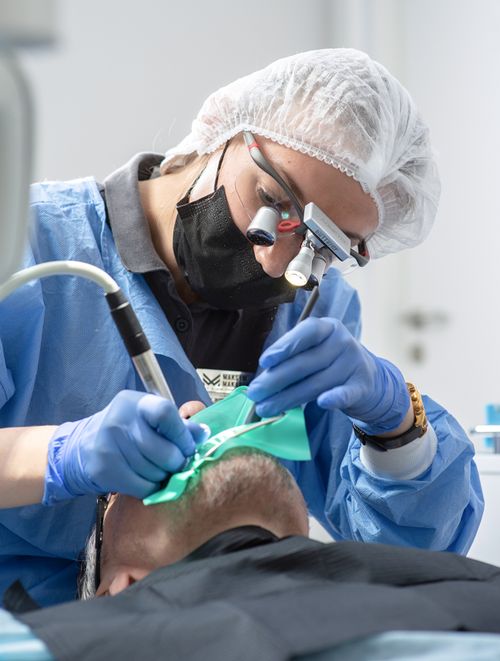 Free A dentist wearing protective gear performs a dental procedure in a clinic. Stock Photo