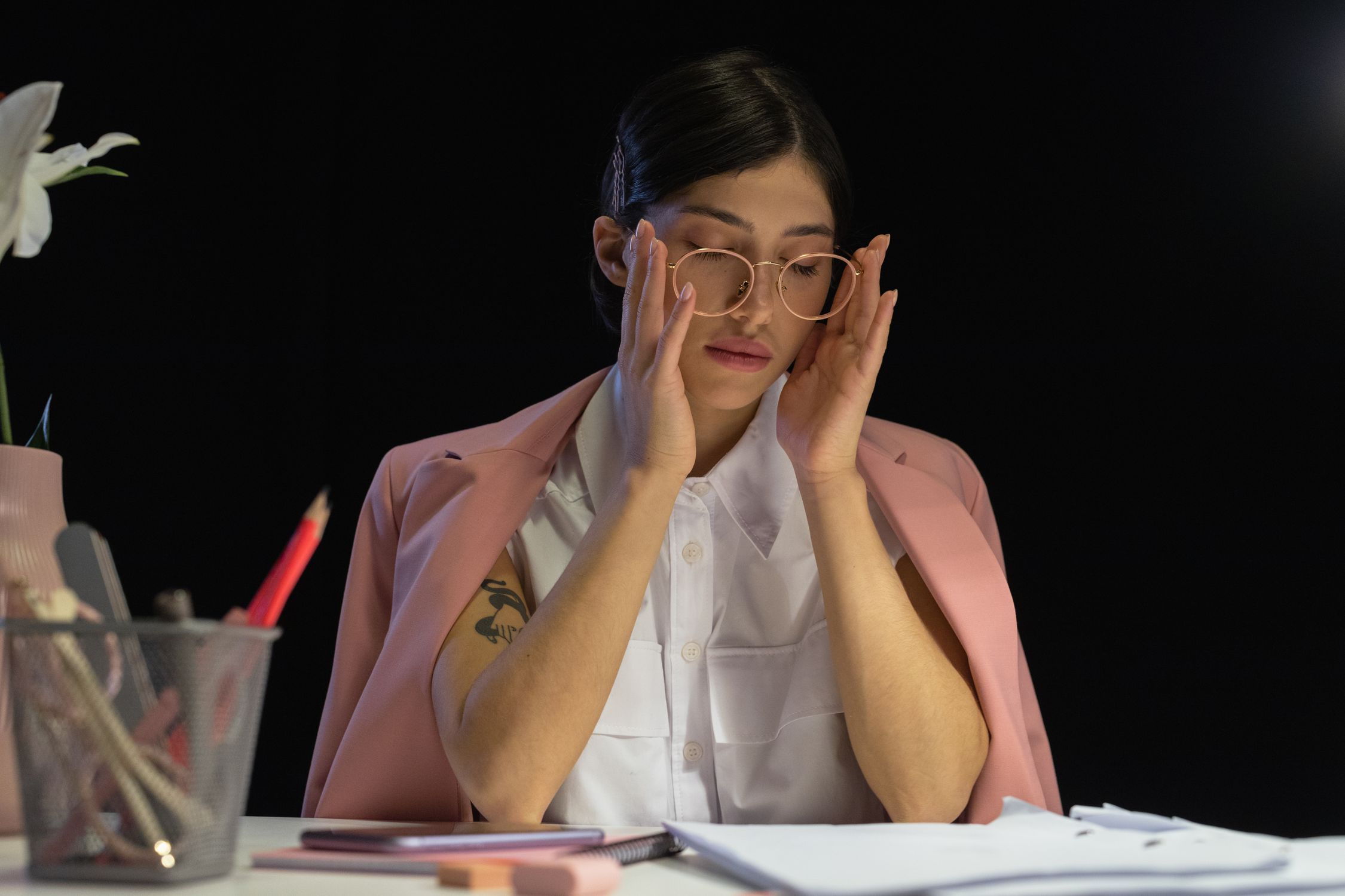 Mulher exausta debruçada sobre a mesa de trabalho, representando os primeiros sinais de burnout feminino
