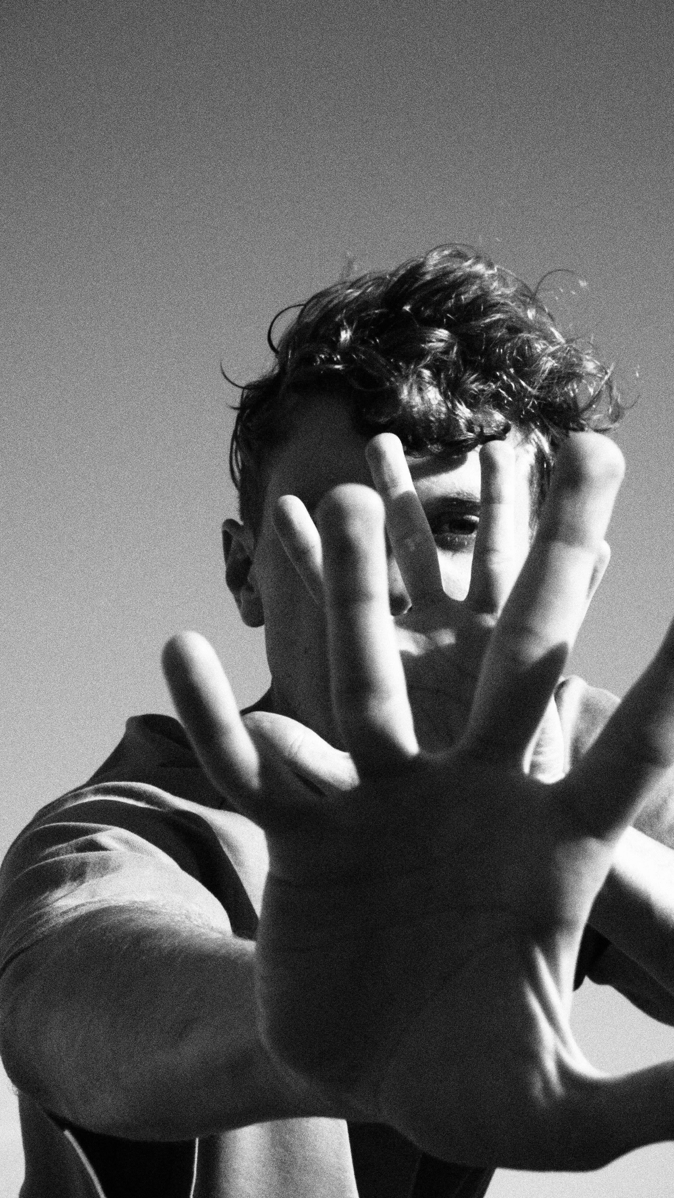 Grayscale Photo of a Man Covering His Face · Free Stock Photo