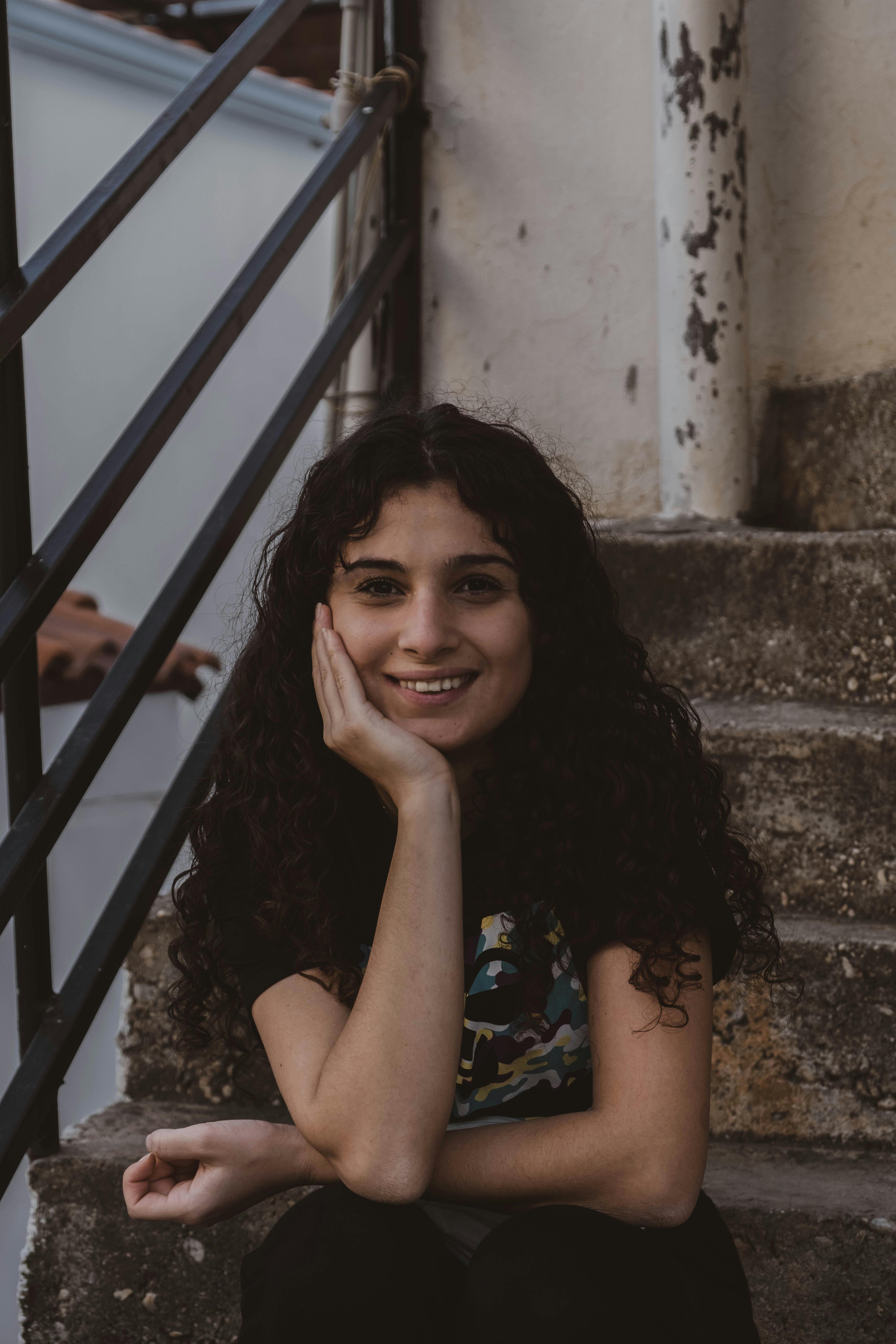 Woman With Hand on Her Face Sitting on Concrete Stairs · Free Stock Photo