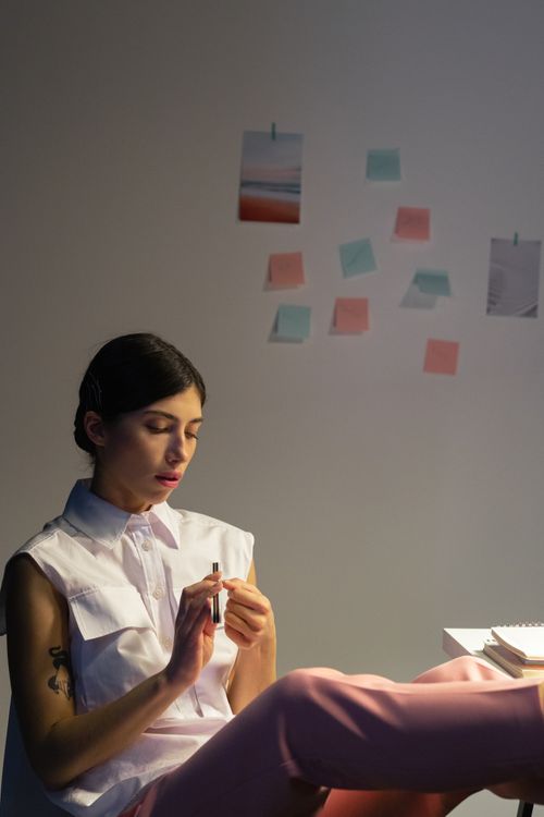Free A young woman in a modern office relaxes with legs up, surrounded by notes and drawings. Stock Photo