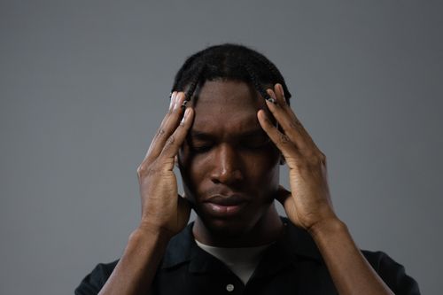 Free A contemplative black man with braided hair in a deep and emotional portrait. Stock Photo