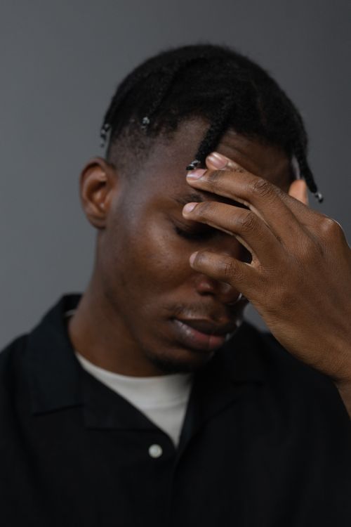 Free A close-up portrait of a young man appearing stressed and contemplative. Stock Photo