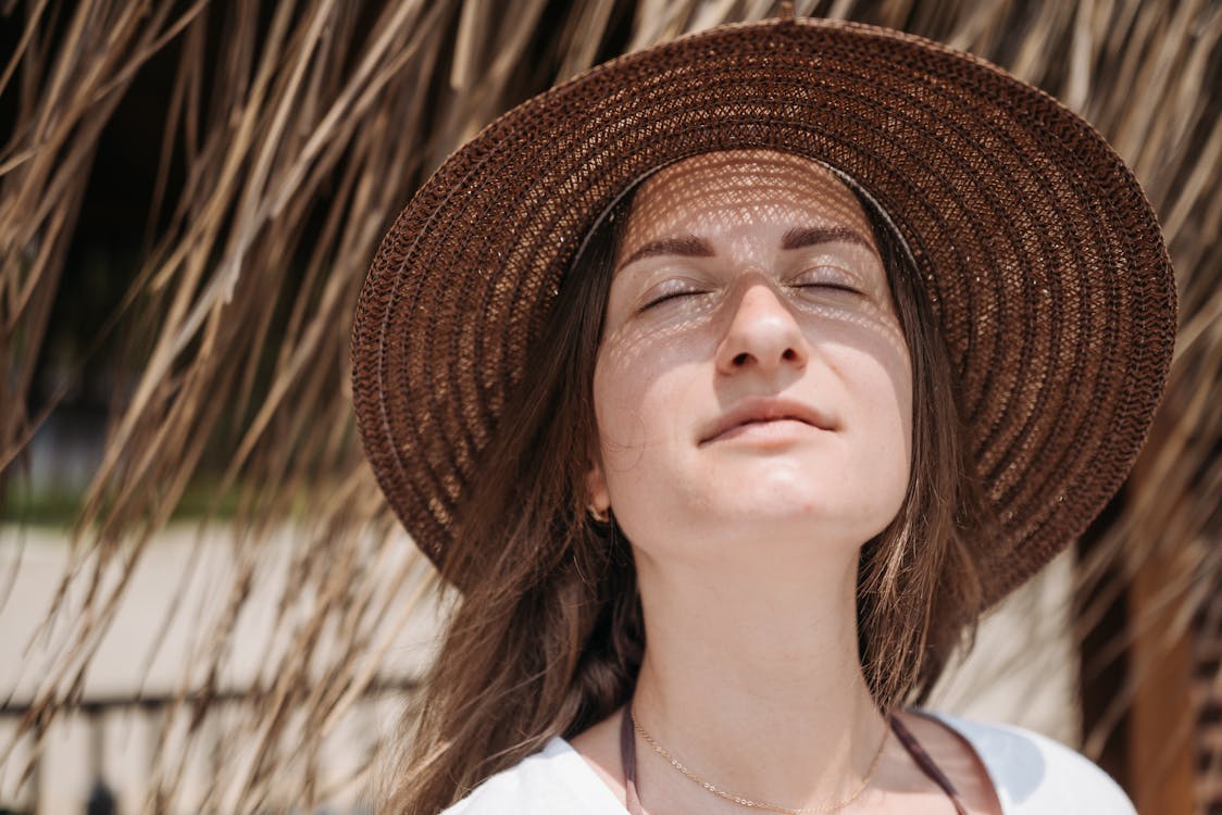 Portrait of a Woman in a Brown Hat Closing Her Eyes · Free Stock Photo