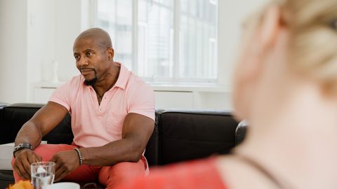 A mentor in discussion reflects on mental health, seated in a bright room.