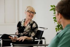 Blonde woman with glasses actively talking during an indoor counseling session.