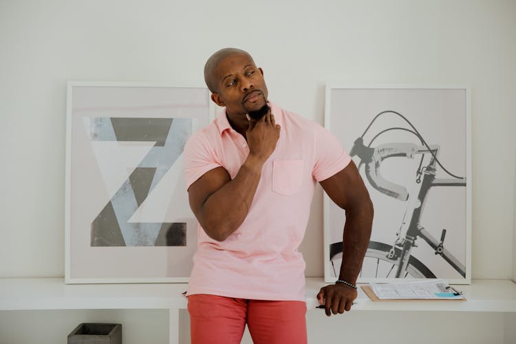 A Man In Pink Polo Shirt Leaning On A Cabinet