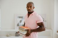 Man in Pink Button Up Shirt Holding Books
