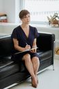 Woman in Black V Neck Shirt Sitting on Black Leather Couch