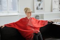 Woman in Red Robe Sitting on Black Leather Couch