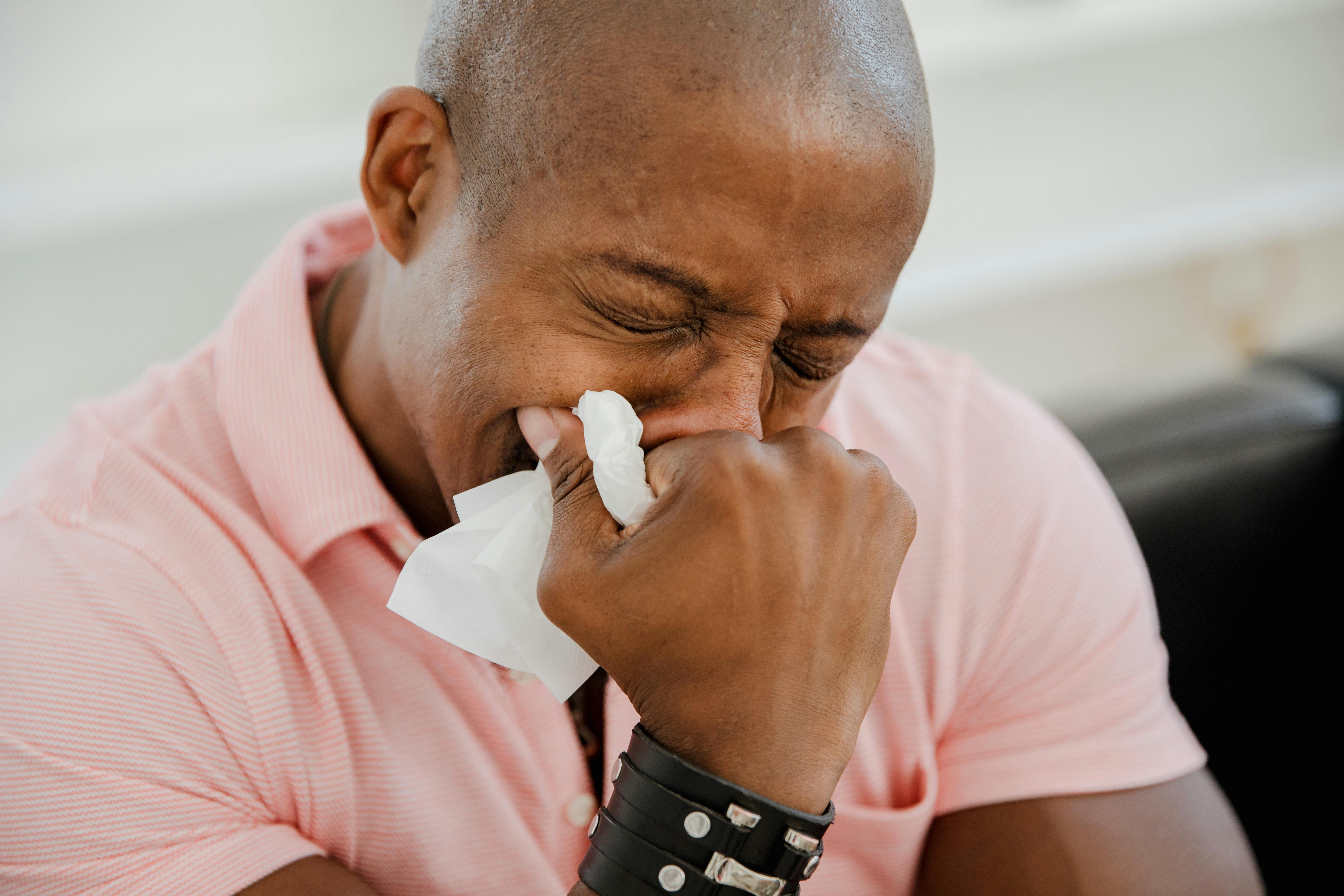 close up photo of man crying in pink shirt