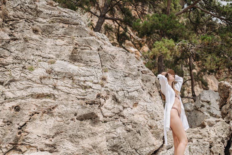 Woman In Swimwear Posing Near Rock Formation