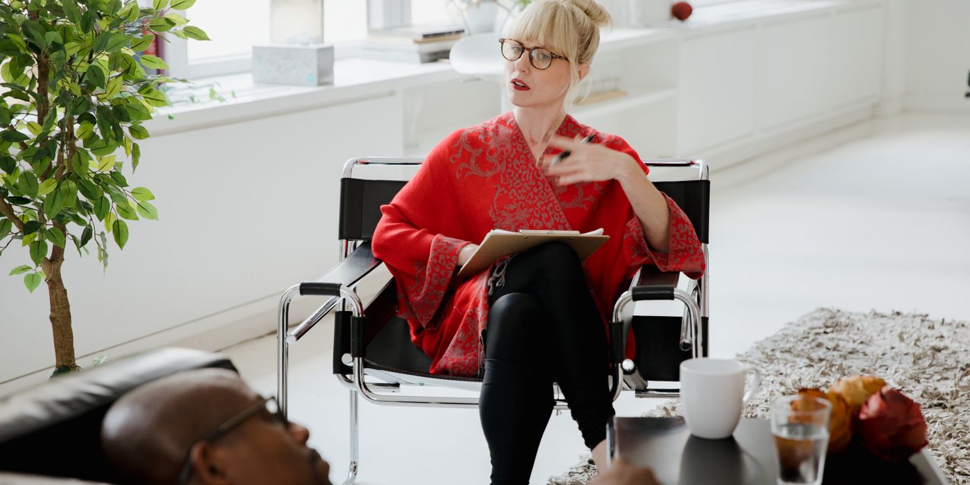 A therapist consults with a patient in a bright, modern office setting.
