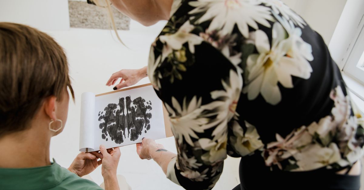 A therapist and patient analyze a Rorschach inkblot test in a counseling session.