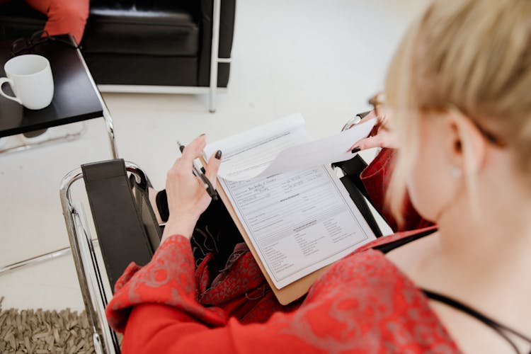 Woman Sitting On Chair Reading Documents 