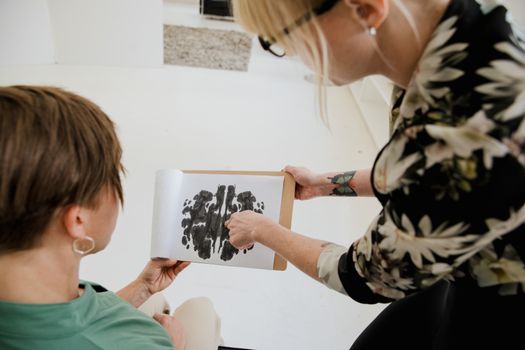 Therapist discussing Rorschach inkblot test with a client in a therapy session.