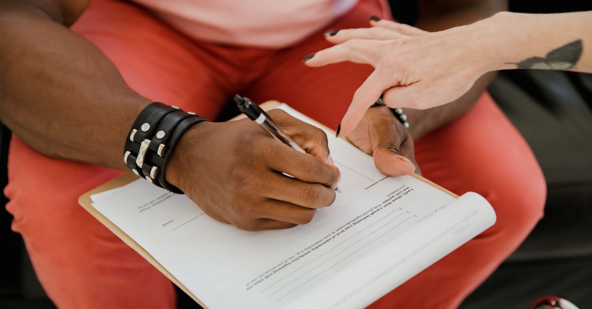 Buyer signing a real estate purchase contract, showing the legal side of buying a Toronto home on a work permit