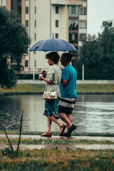 A couple walks by a river under an umbrella in rainy Kaliningrad, Russia.