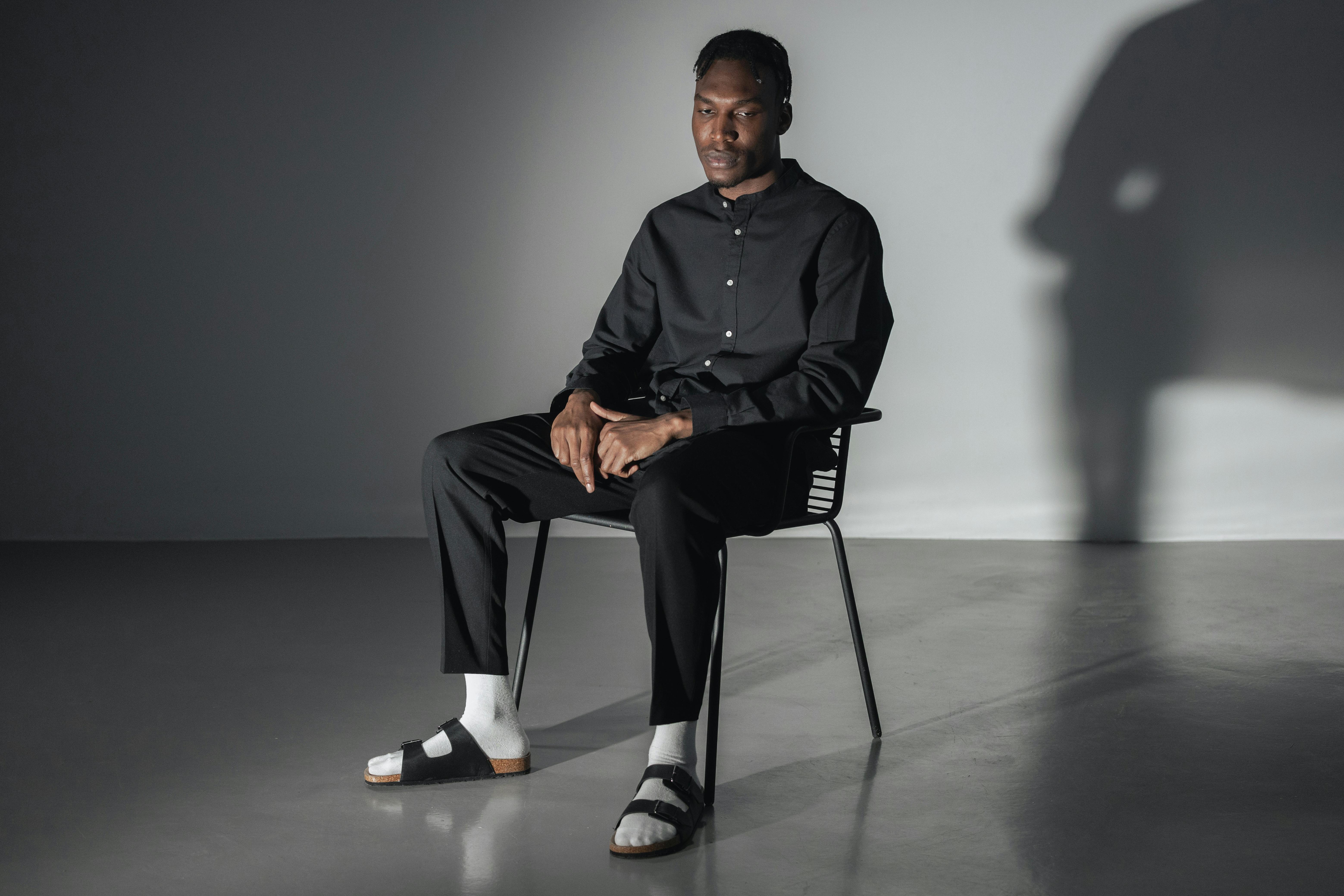 Portrait of a man in a minimalist studio setting, creating a thoughtful atmosphere.