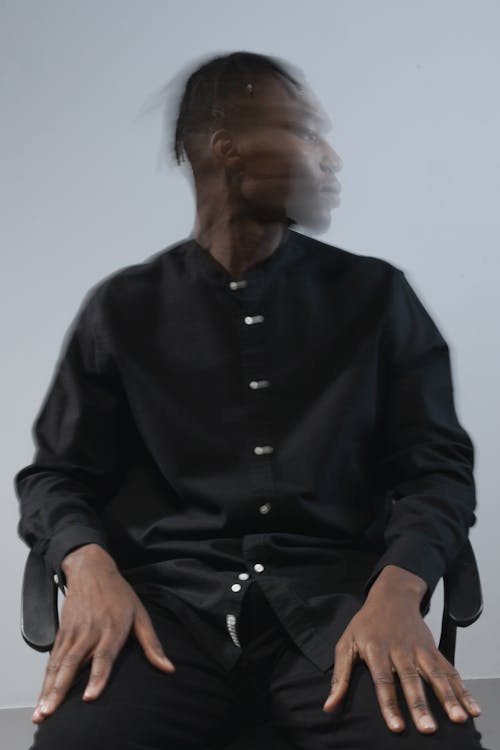 A Man in Black Long Sleeves Sitting on the Chair