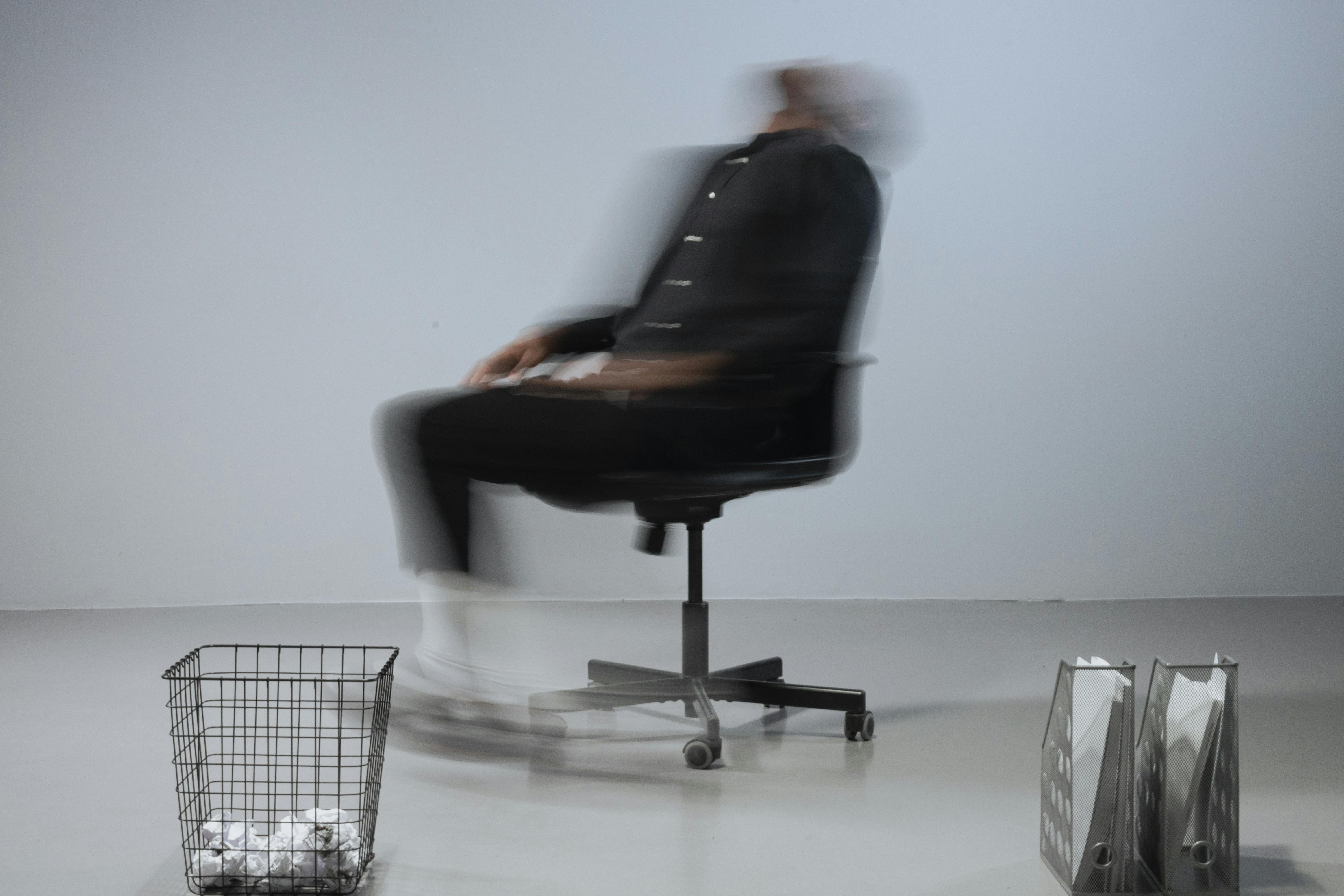 blurred photo of a man sitting on an office chair