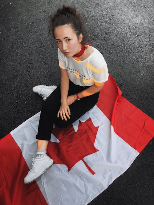 Young Woman Sitting on a Canadian Flag 