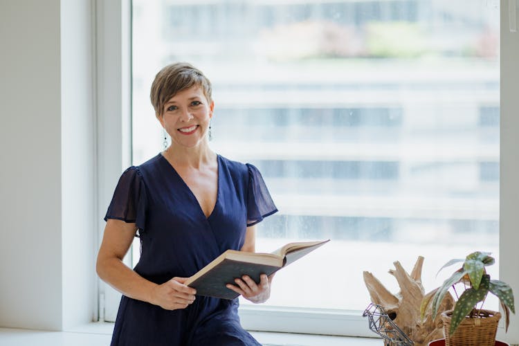 Woman In Blue Dress Holding A Book