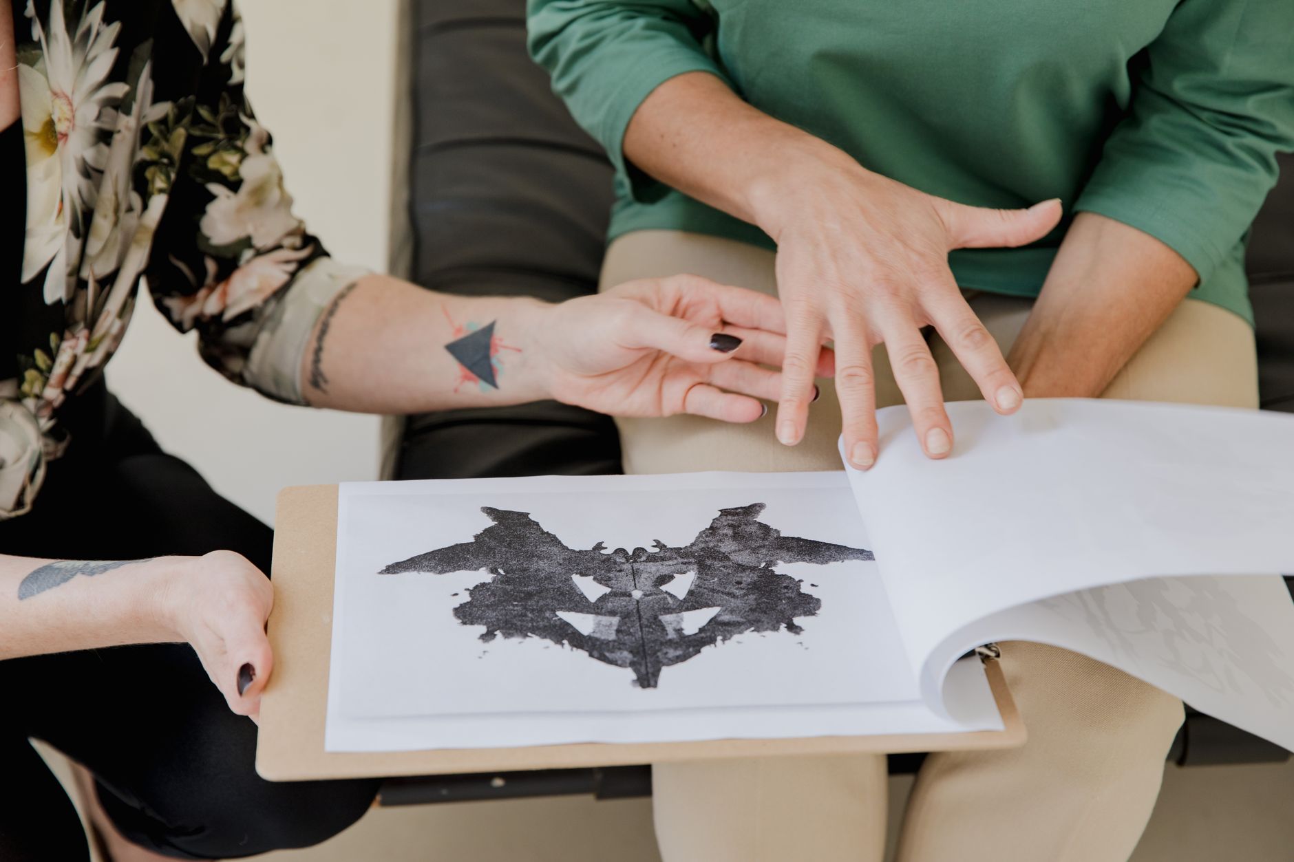 Two professionals discussing behavioral patterns and Rorschach inkblots in a research setting.