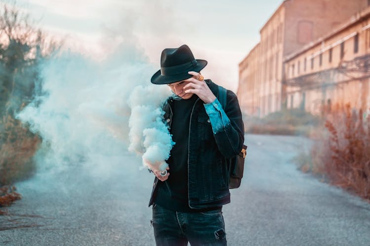 Man In A Hat Holding A Smoke Flare 