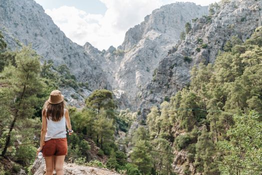 Woman enjoying nature on a hike with stunning mountain views.