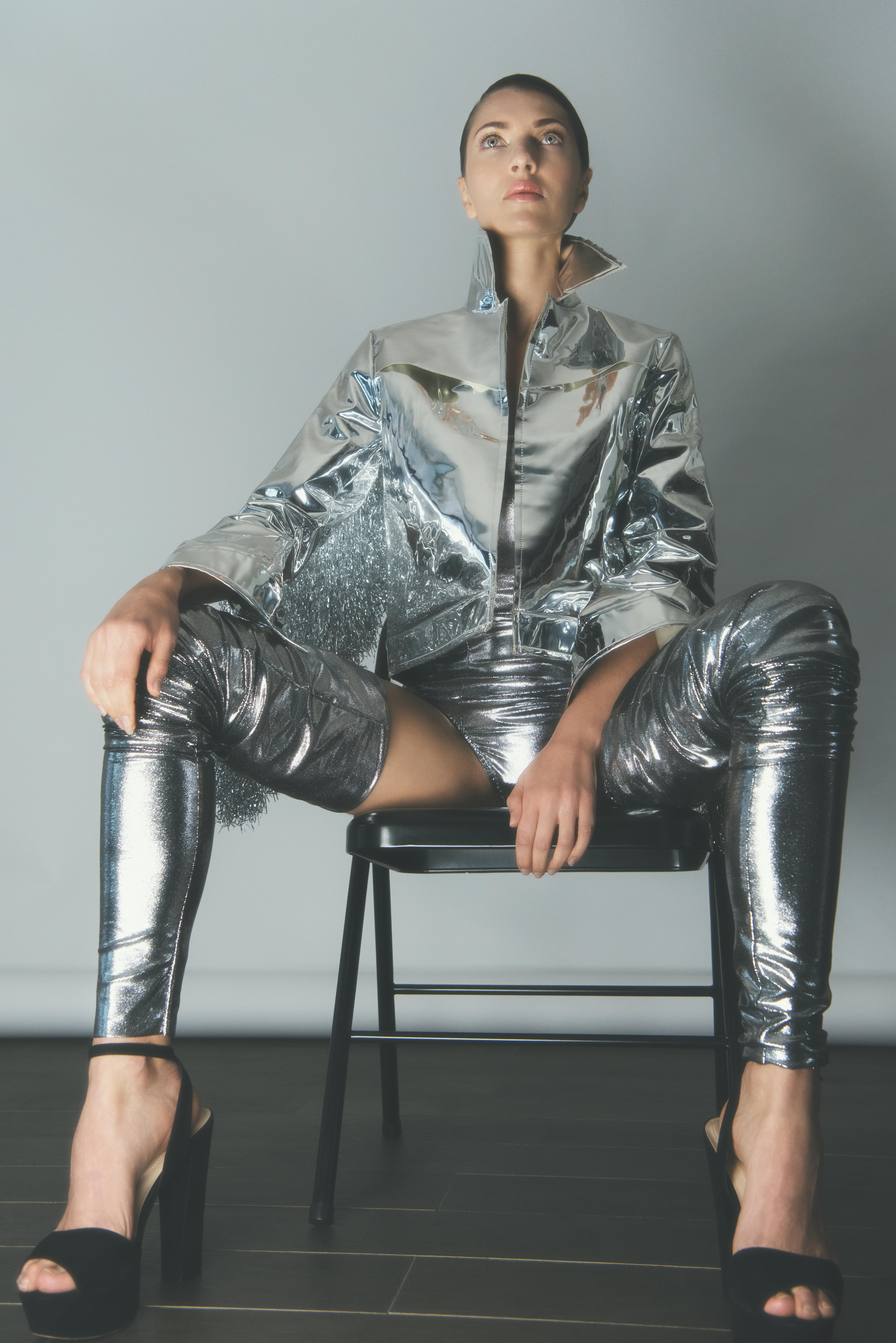 woman in silver outfit sitting on black chair