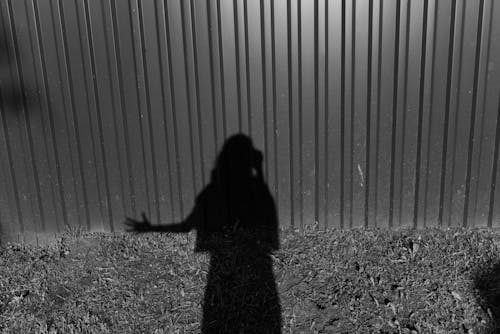 Free Shadow of Person Standing on Metal Wall Stock Photo