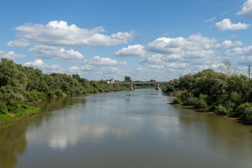 Free Tranquil summer view of a river with lush greenery and a bridge in Tyumen, Russia. Stock Photo