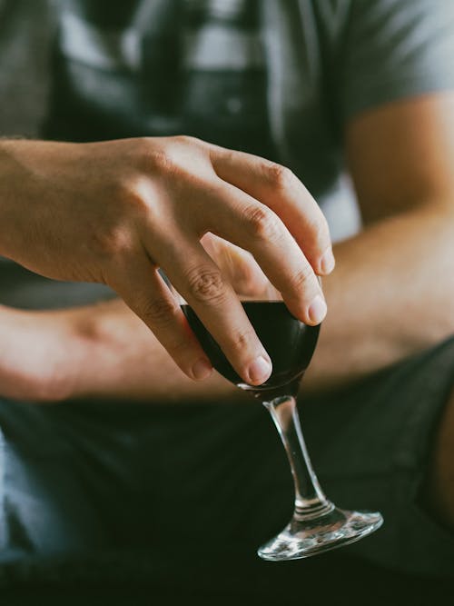 Close-Up Shot of a Person Holding a Glass of Wine