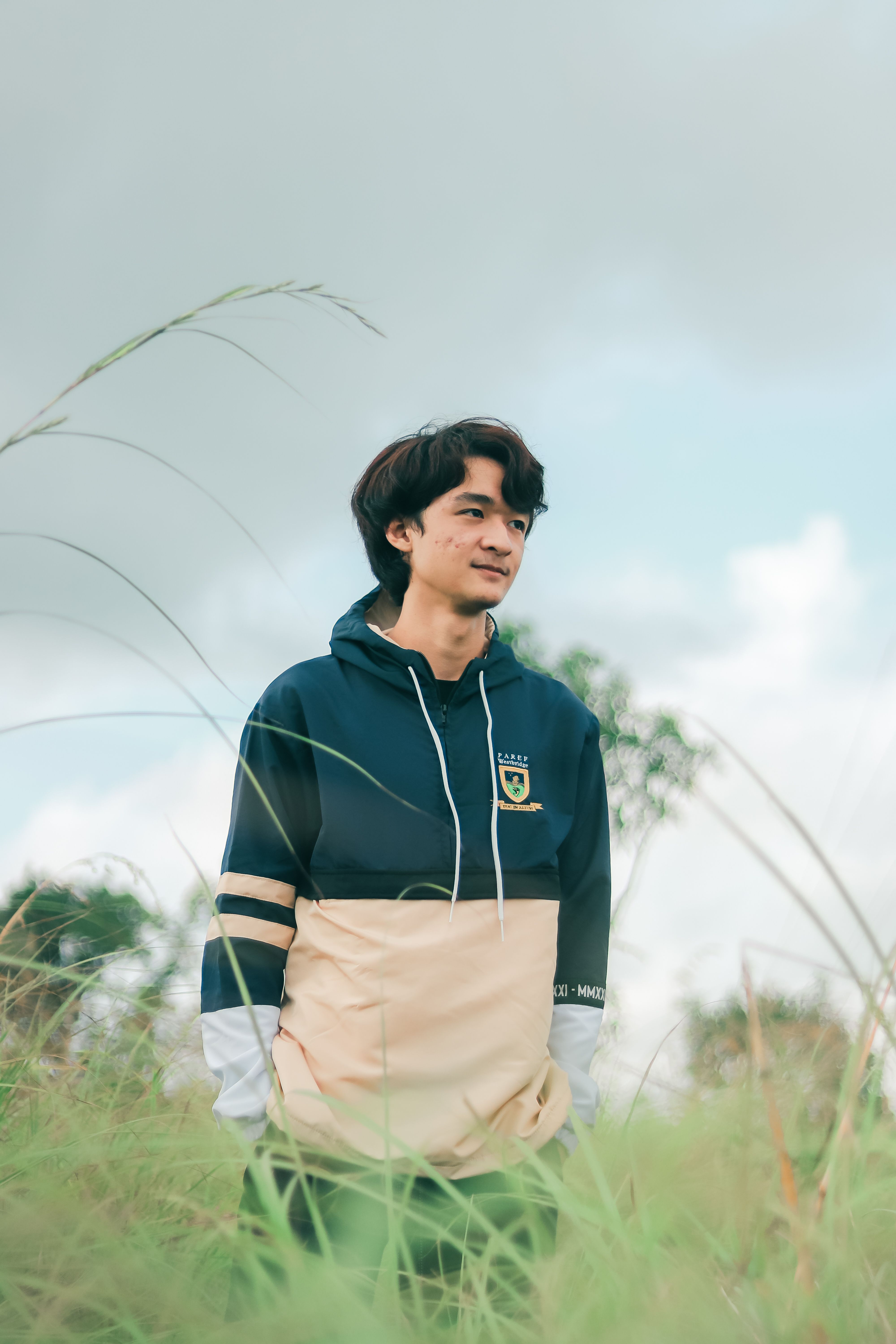 Person in Mustard Hoodie Standing on Green Grass Field · Free Stock Photo