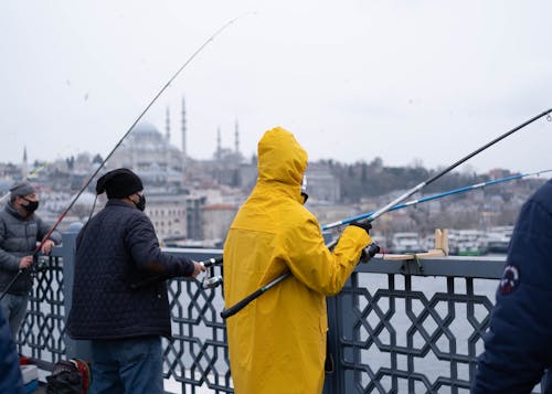 Free People Wearing Jacket Holding Fishing Rods Stock Photo