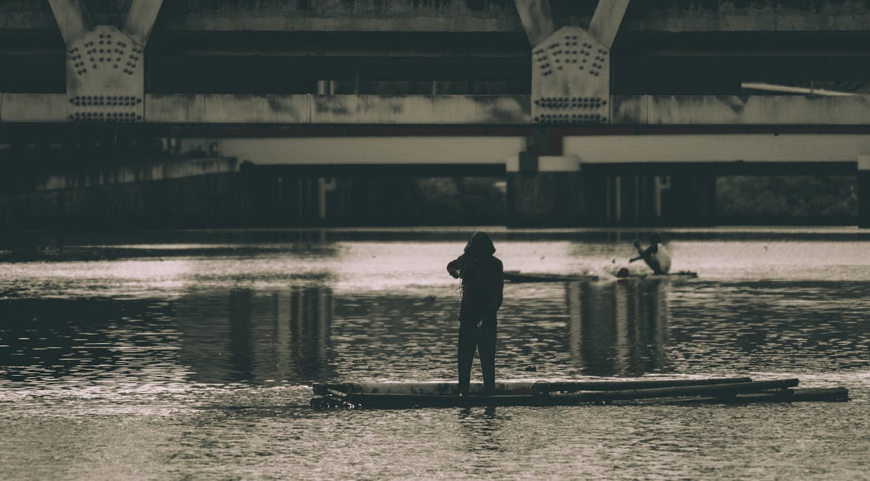 一个女人在水体旁边的灰度摄影