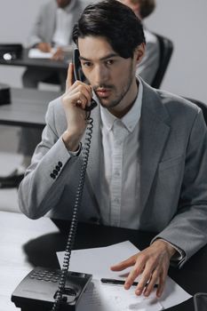 Man in Gray Suit Jacket Holding Black Smartphone