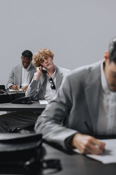 Three diverse men working intently in a modern office space, showcasing teamwork and focus.