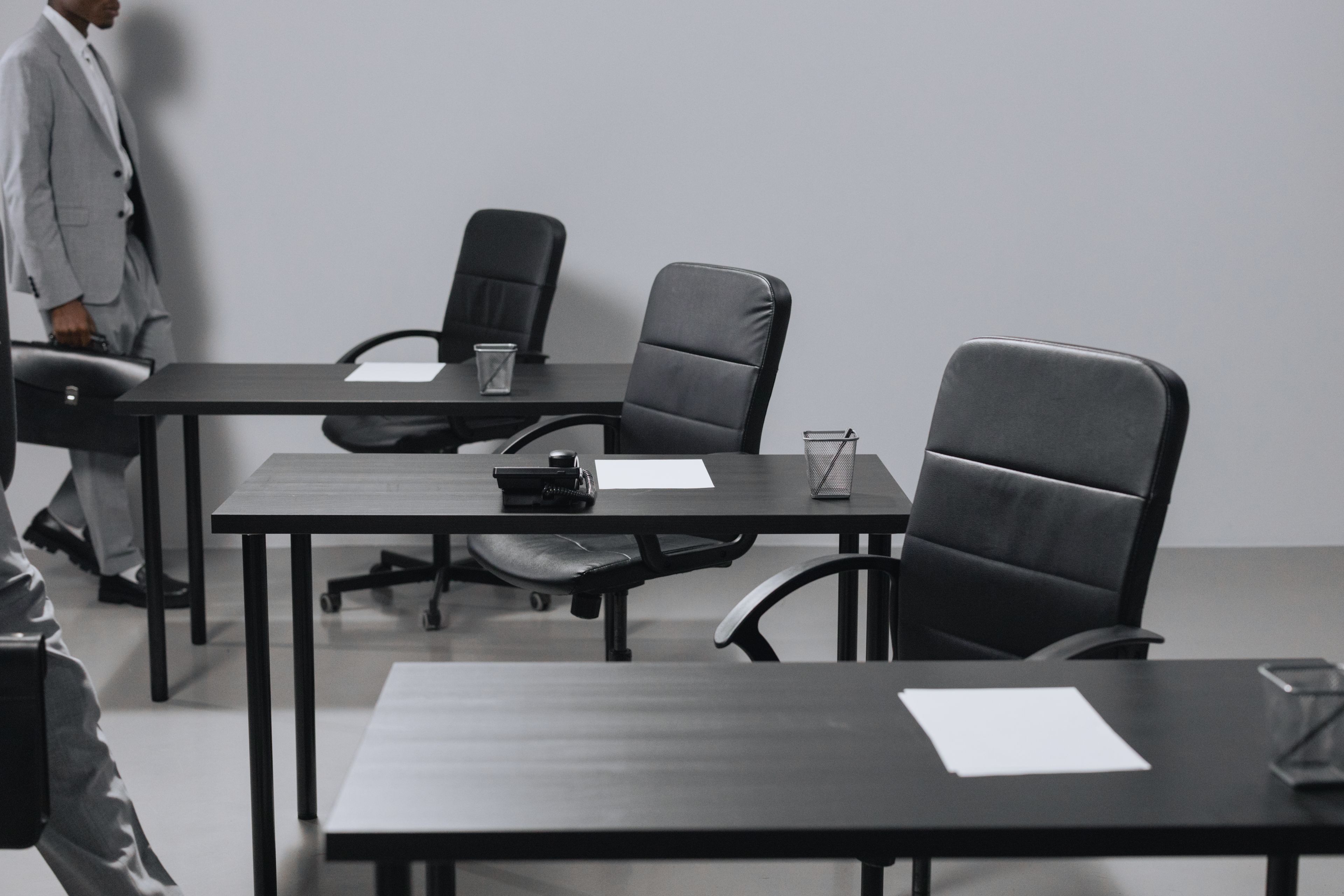 Espace de bureaux contemporain aux fauteuils en cuir noir et postes alignés