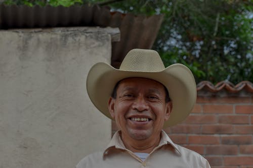 Free Close-Up Photo of a Man in a Beige Cowboy Hat Looking at the Camera Stock Photo