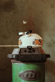 A vintage floral kettle sits on a rustic stove, evoking nostalgia and warmth.