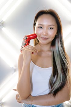 Portrait of a young woman holding a gaming controller, posing confidently indoors.